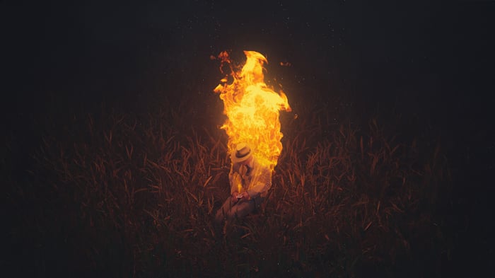 Person engulfed in flames in a field