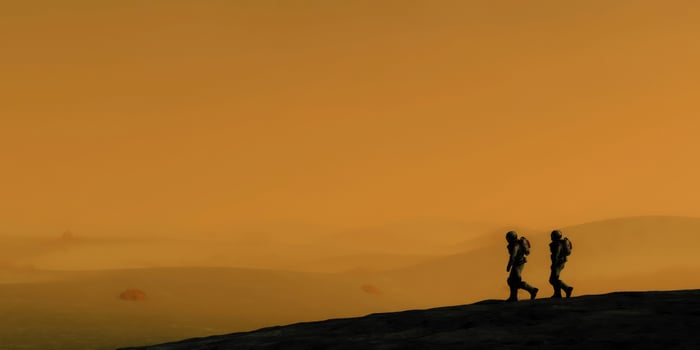 Two astronauts walking on a desolate planet