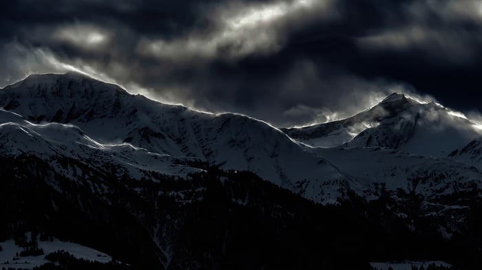 Snowy mountains in Surselva, Switzerland under dark clouds