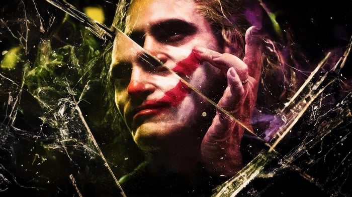 Joker with face paint reflected in broken glass