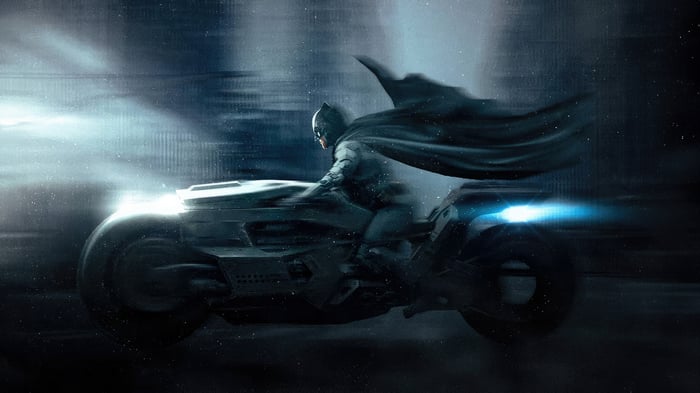 Batman riding the Batmobile at night
