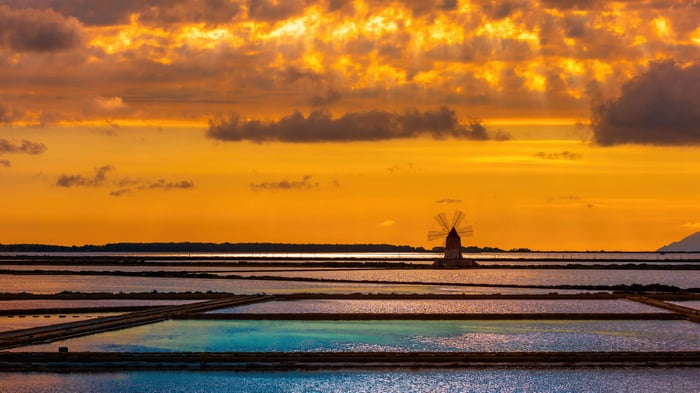 Salt pans and windmill at sunset in Marsala