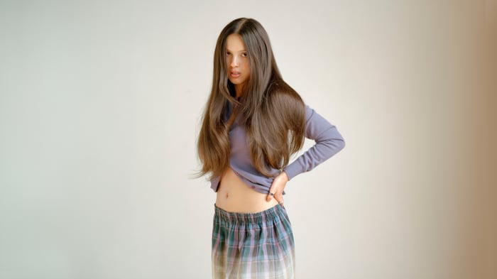 Olivia Rodrigo in a purple sweater and plaid skirt