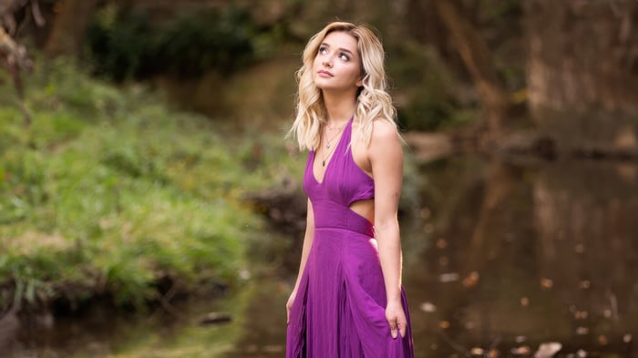 Young woman in a purple dress by the water