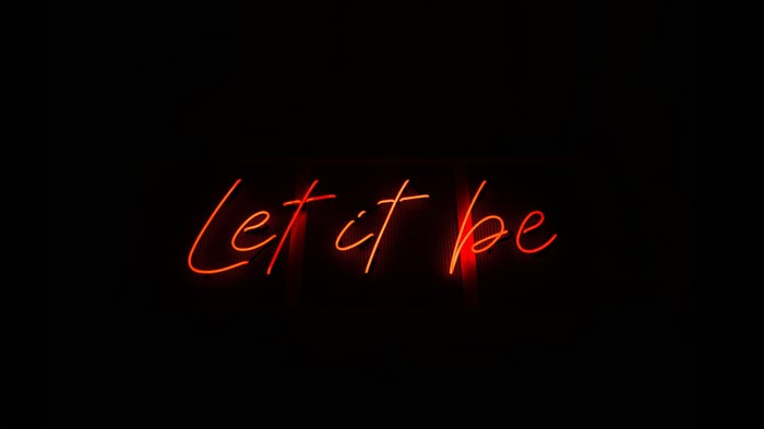 Red Neon Sign "Let It Be" on Black Background