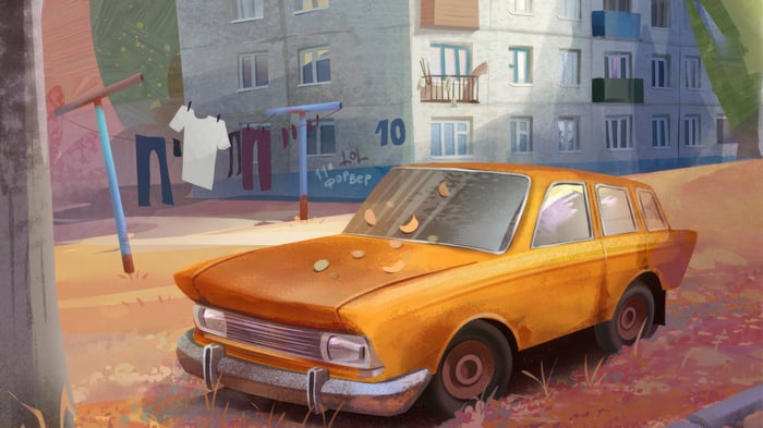 Orange car parked near apartment building with laundry