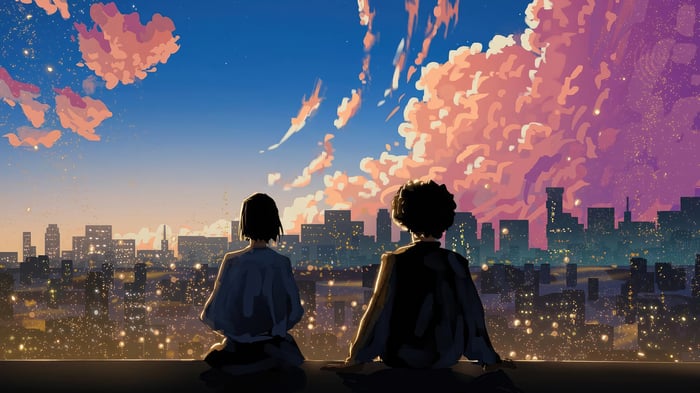 Two people watching city lights at sunset