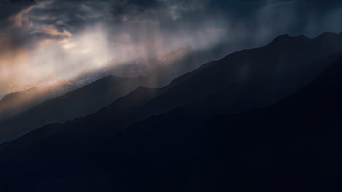 Rain falling on dark mountain ranges