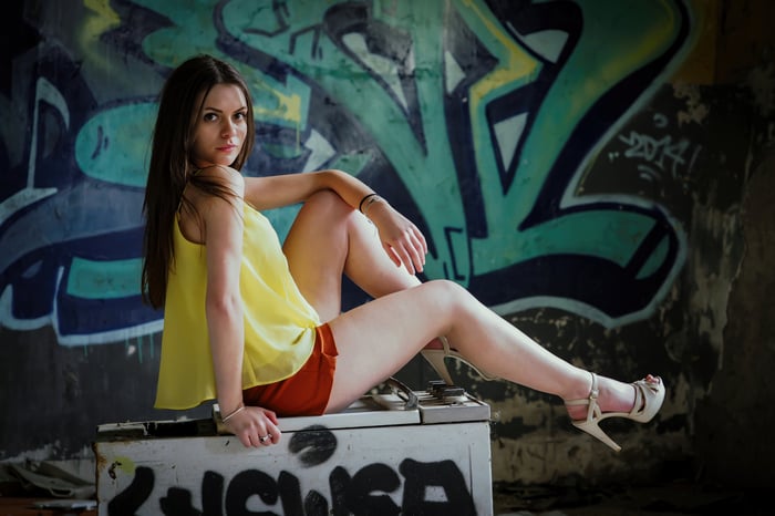 Girl posing in front of graffiti wall