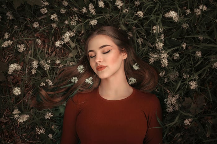 Girl lying on a bed of grass and flowers