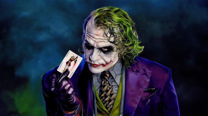 The Joker holding the Ace of Chaos card