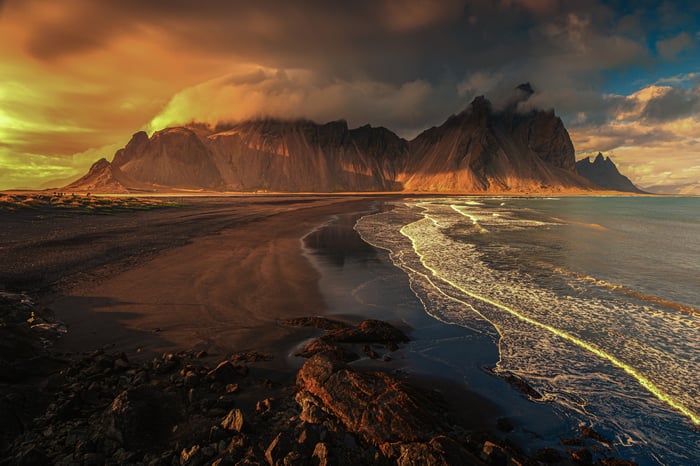 Seashore with dramatic mountains and ocean waves