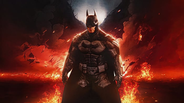 Batman standing in front of a fiery background