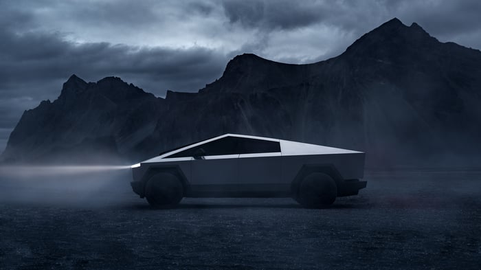 Tesla Cybertruck driving at night in a mountainous landscape