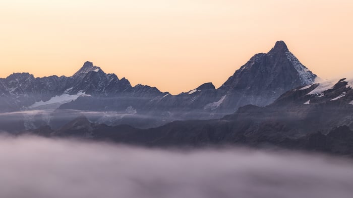 Mountain range shrouded in fog at sunrise