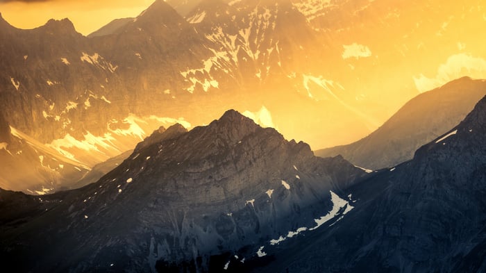 Golden light illuminates majestic mountain peaks in autumn