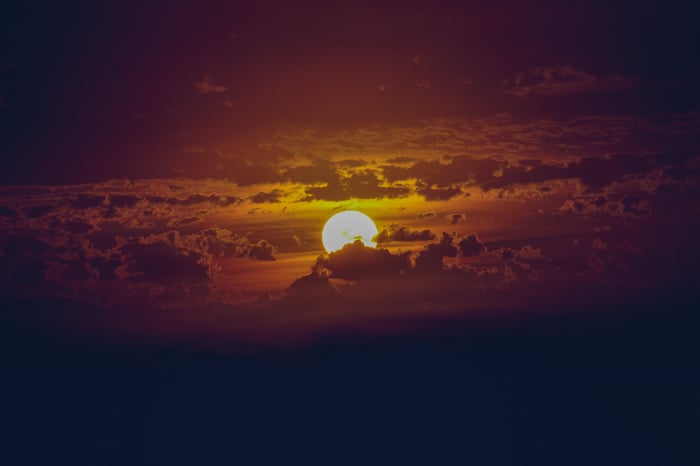 Radiant Sun Peeking Through Clouds at Sunset