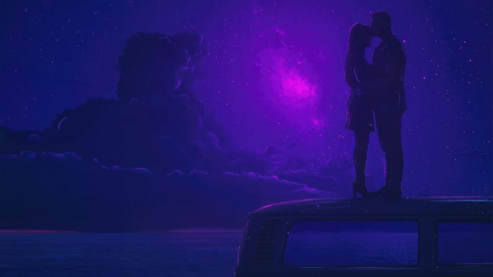 Couple on a van roof under a starry purple sky