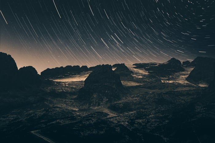 Star Trails Over Rocky Terrain at Night