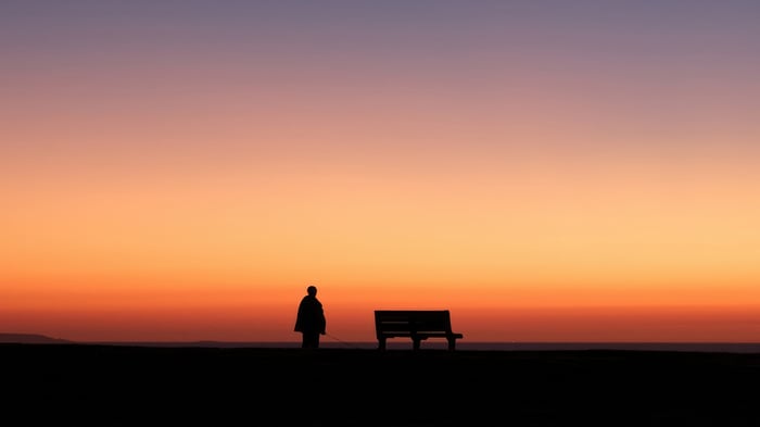 Silhouette of a person and a bench at sunset