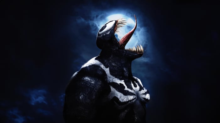 Venom with tongue out against a full moon