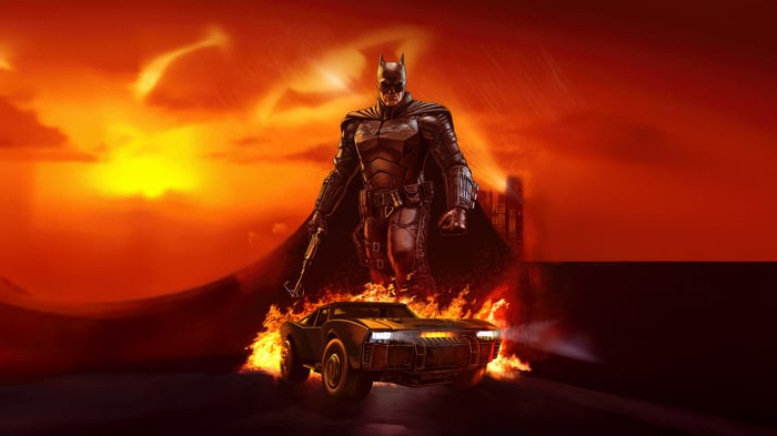 Batman and Batmobile in a fiery landscape