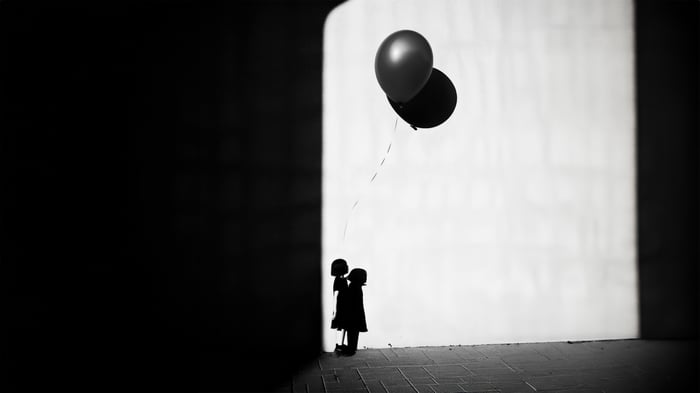 Girl holding balloons in monochrome