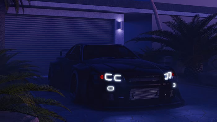 Black sports car parked in front of a garage at night