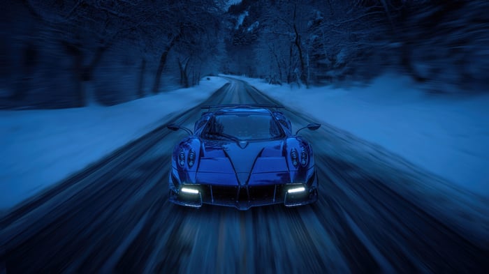 Blue Pagani Huayra Roadster driving on a snowy road
