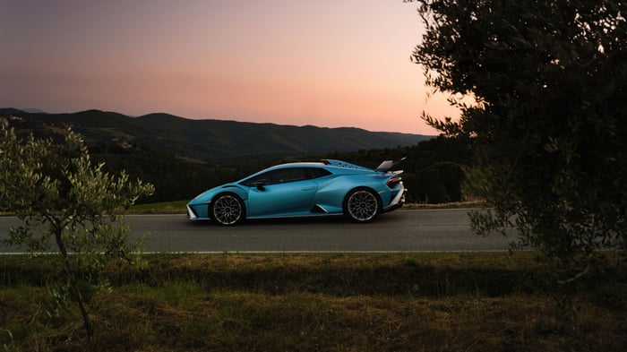 Blue Lamborghini STO on a road at sunset