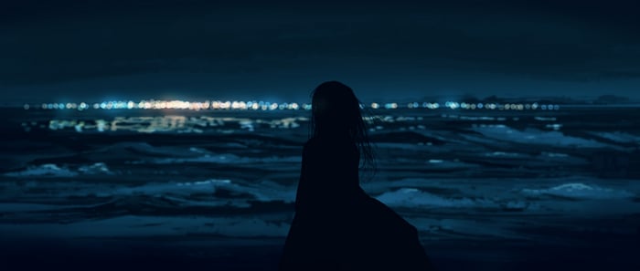 Silhouette of a woman gazing at the sea at night