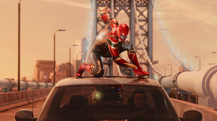 Spider-Man on a car roof with a bridge in the background