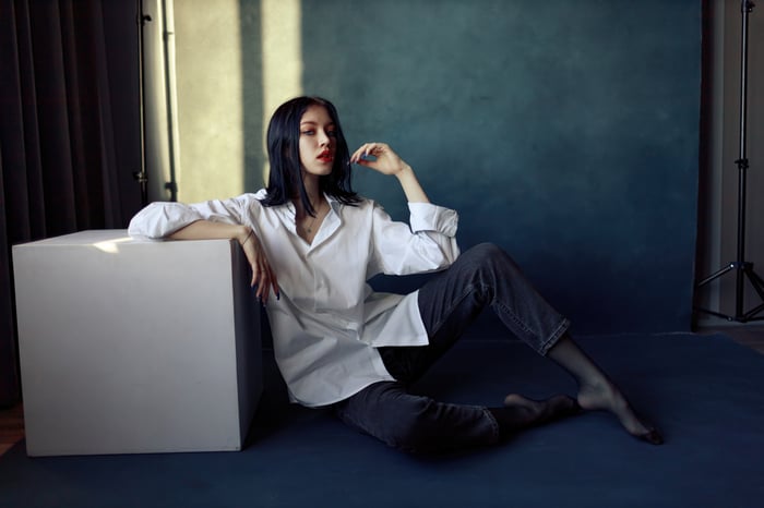 Girl in jeans and white shirt sitting indoors
