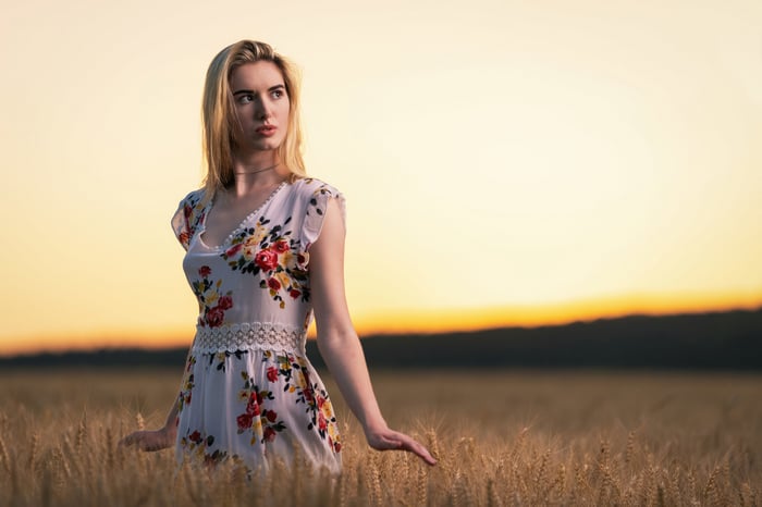 Blonde girl in a floral dress in a wheat field