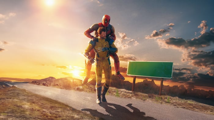 Deadpool carrying Wolverine on a road at sunset