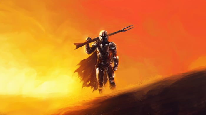 The Mandalorian walks across a desert landscape