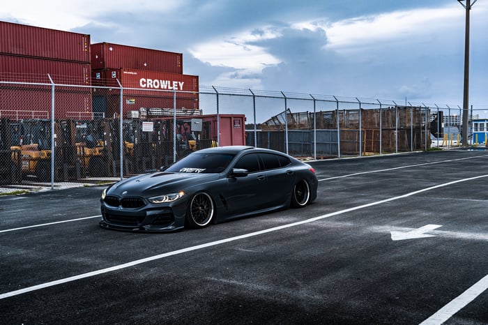 Dark BMW 850i parked at a shipping yard