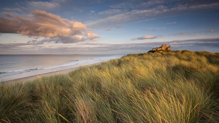 Bamburgh Castle on a grassy dune overlooking the sea