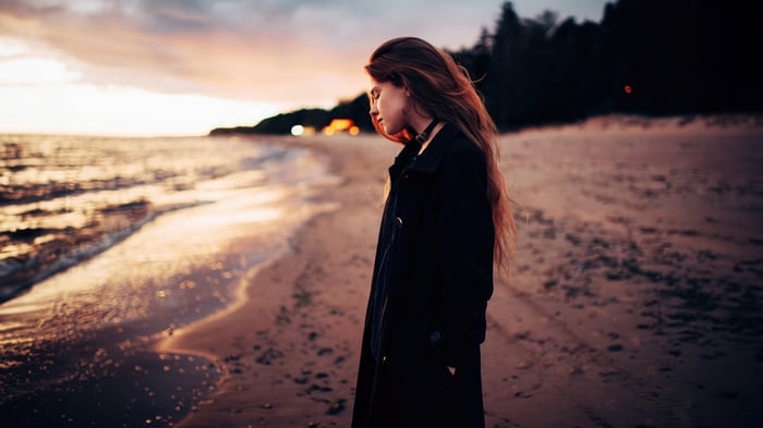 Woman with wavy hair on a beach at sunset