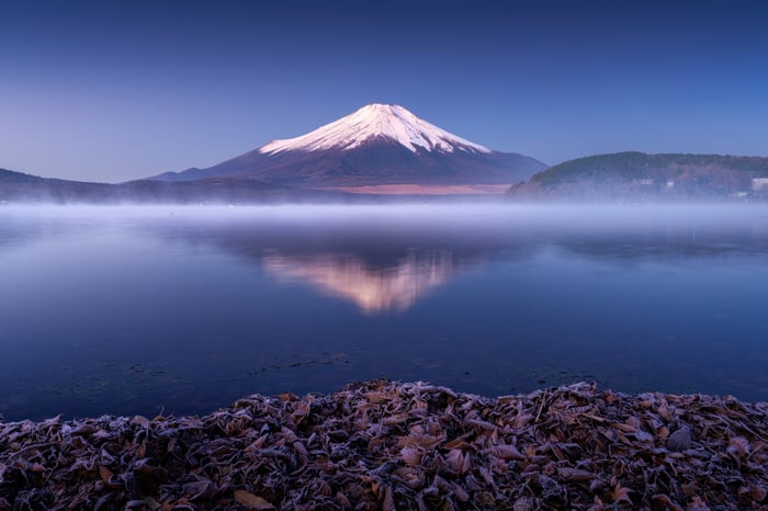Mount Fuji reflected in a misty lake at dawn