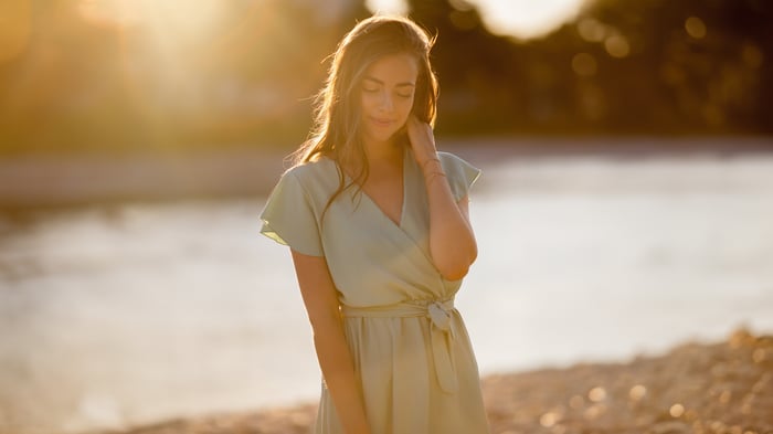 Woman in a light green dress by the water