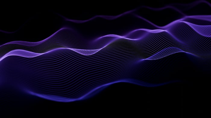 Abstract purple waves of light on a black background
