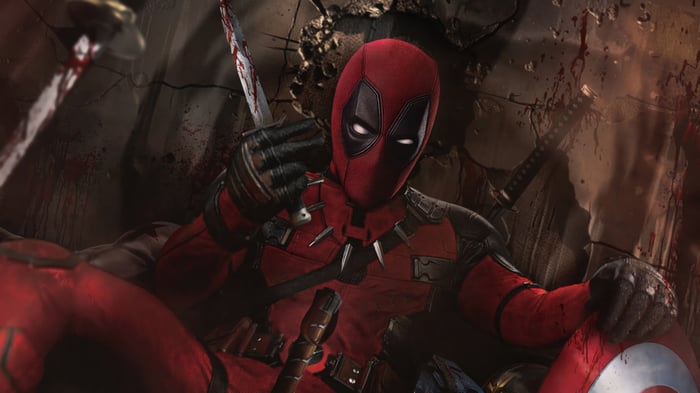 Deadpool sitting in a bloody environment