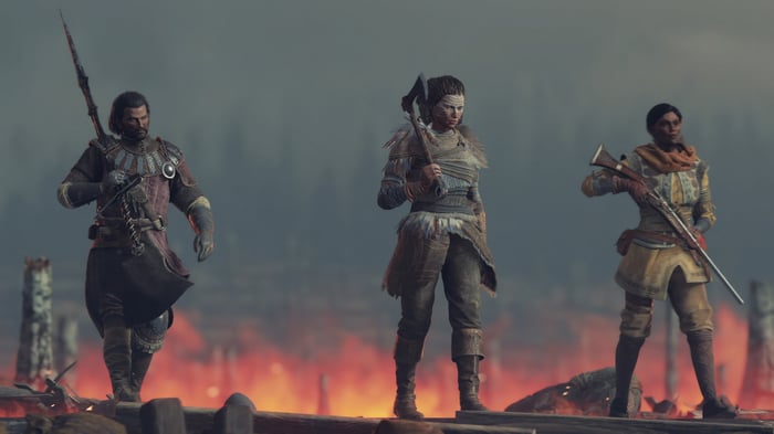 Greedfall 2 characters with weapons in front of fire