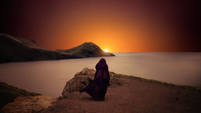 The Acolyte watches the sunset over the ocean