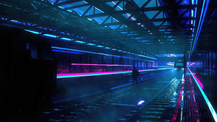 Neon-lit train station with a lone figure
