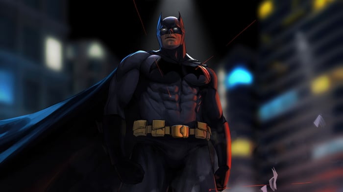 Batman stands in a city at night