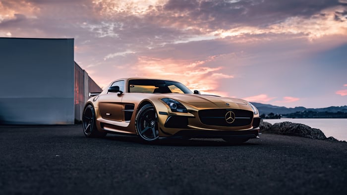 Gold Mercedes-Benz SLS AMG parked by the water