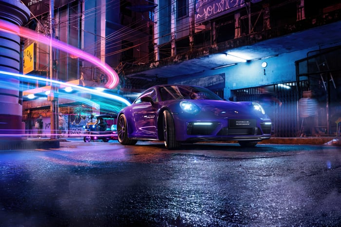 Purple Porsche on a wet city street at night