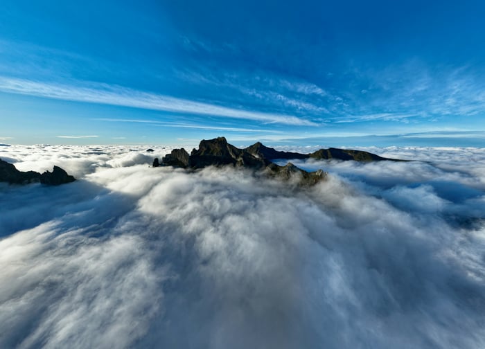 Mountains above the clouds under a blue sky